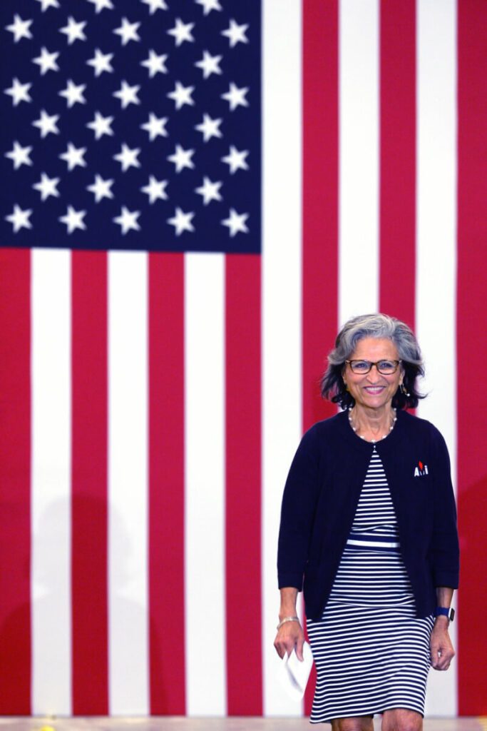 Woman standing in front of an American flag.