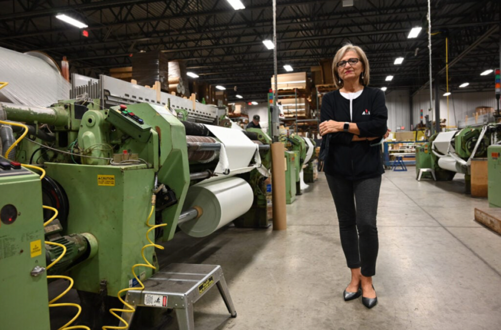 Woman standing by machinery.